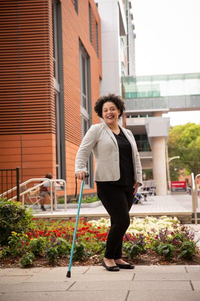 Natasha Graves standing with her cane outside