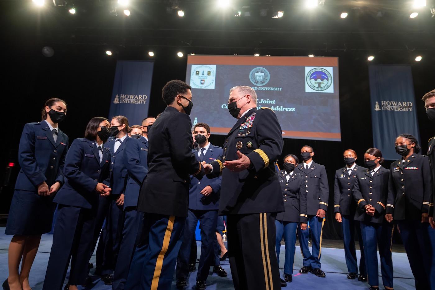 ROTC leader shanking hands with cadets at graduation