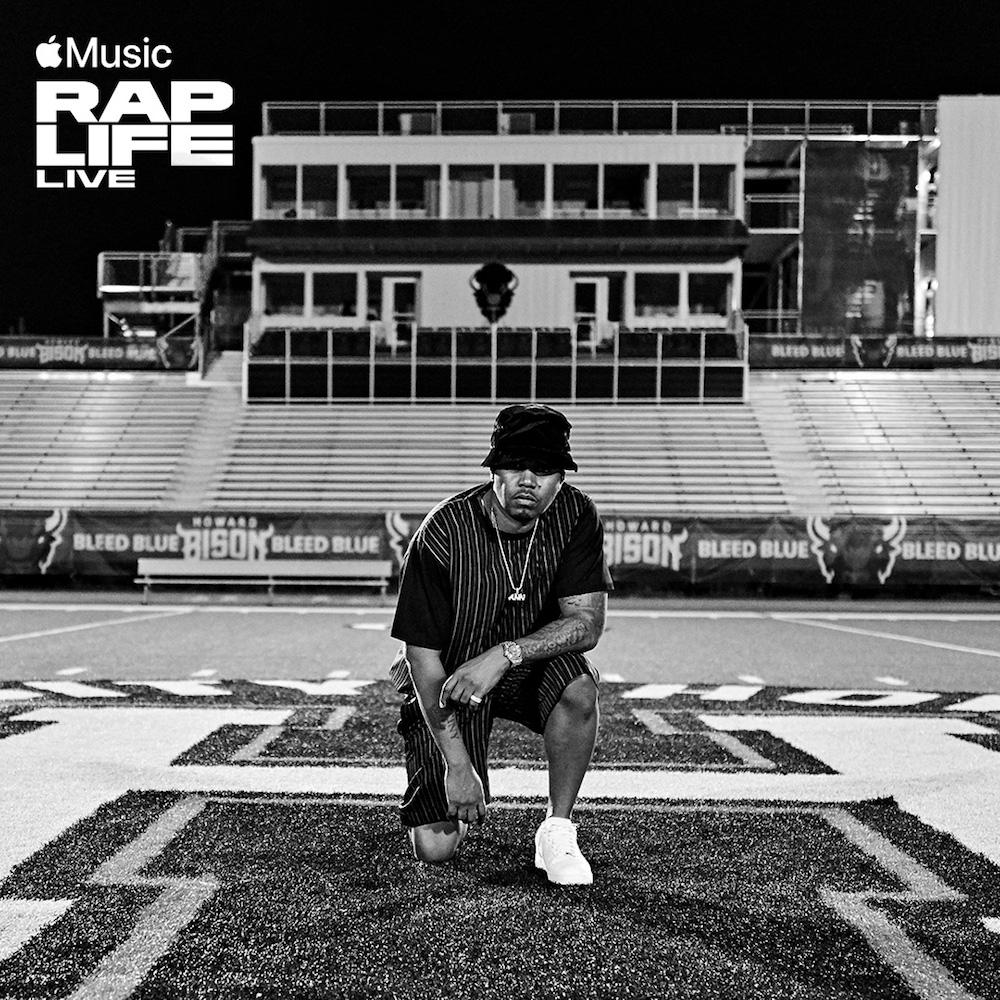 Man with a bucket hat kneeling on a football field