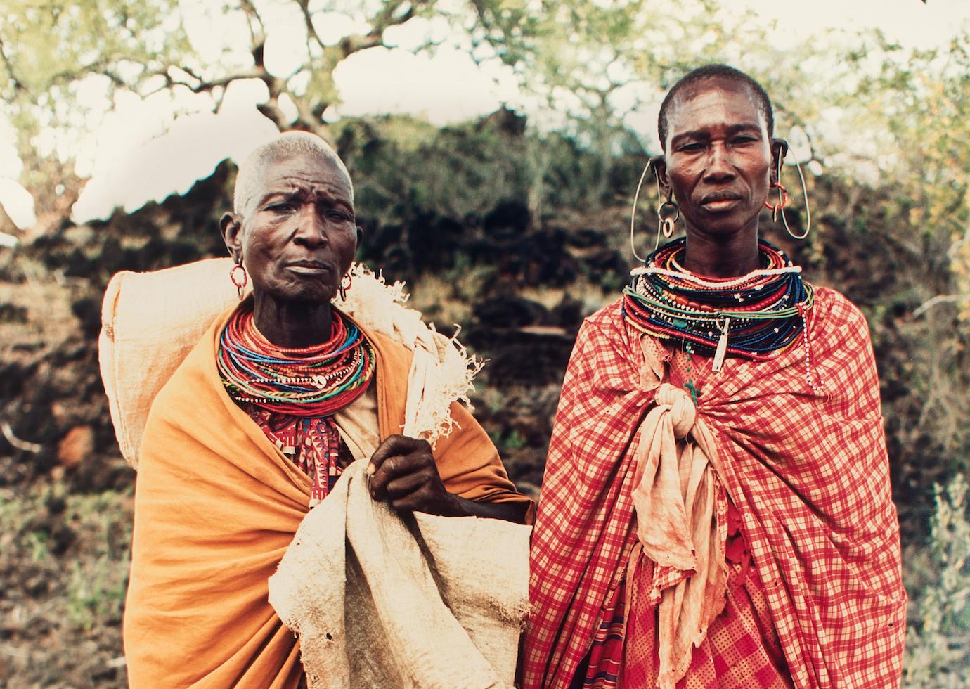 Two people standing in traditional clothing outside