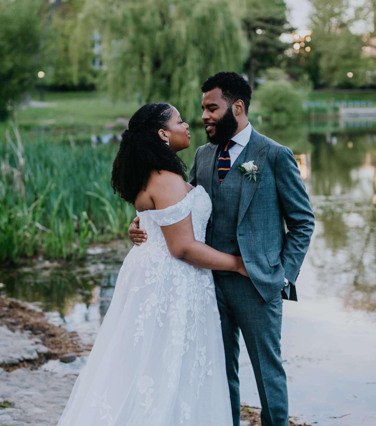 Bride and Groom standing at a pond 
