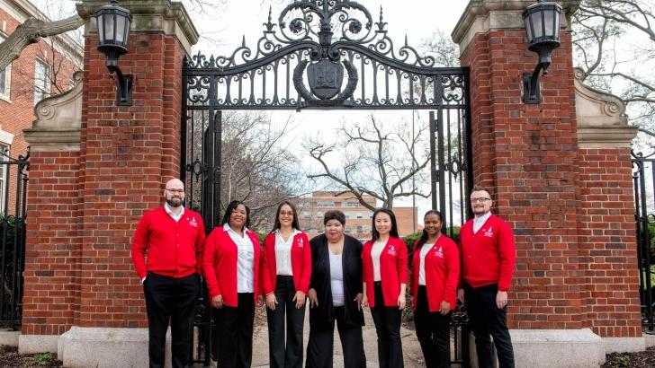 IRA staff standing in front of Howard gates in matching sweaters