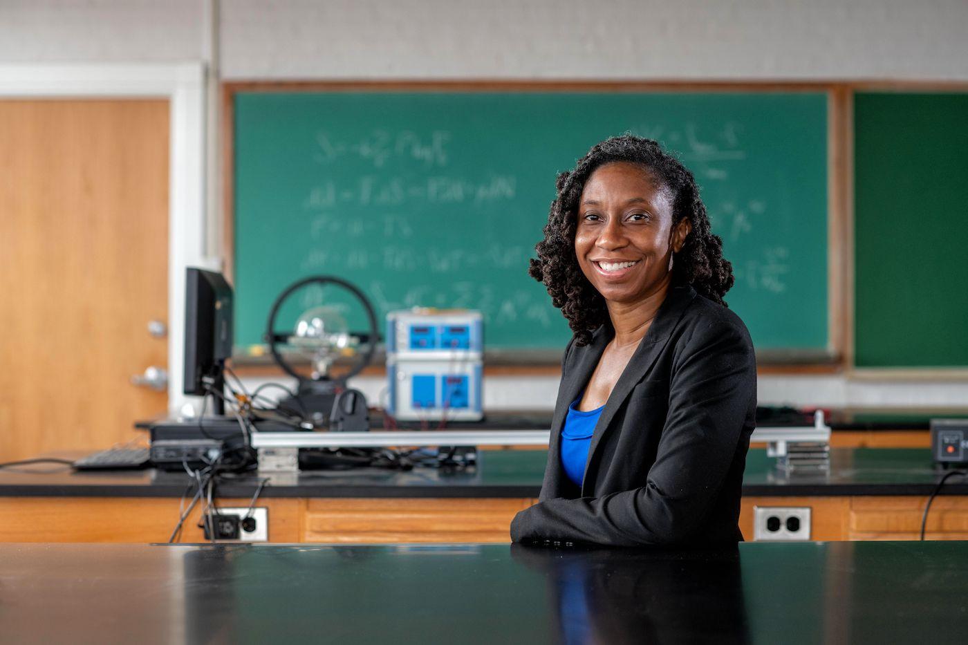 Kenisha Ford leaning against a lab table in a classroom
