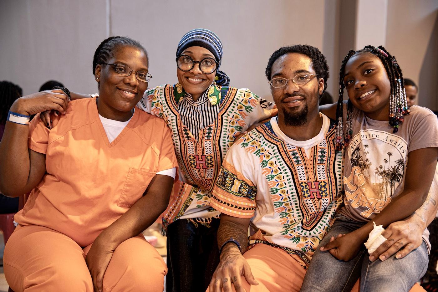 Four people sitting in a line hugging