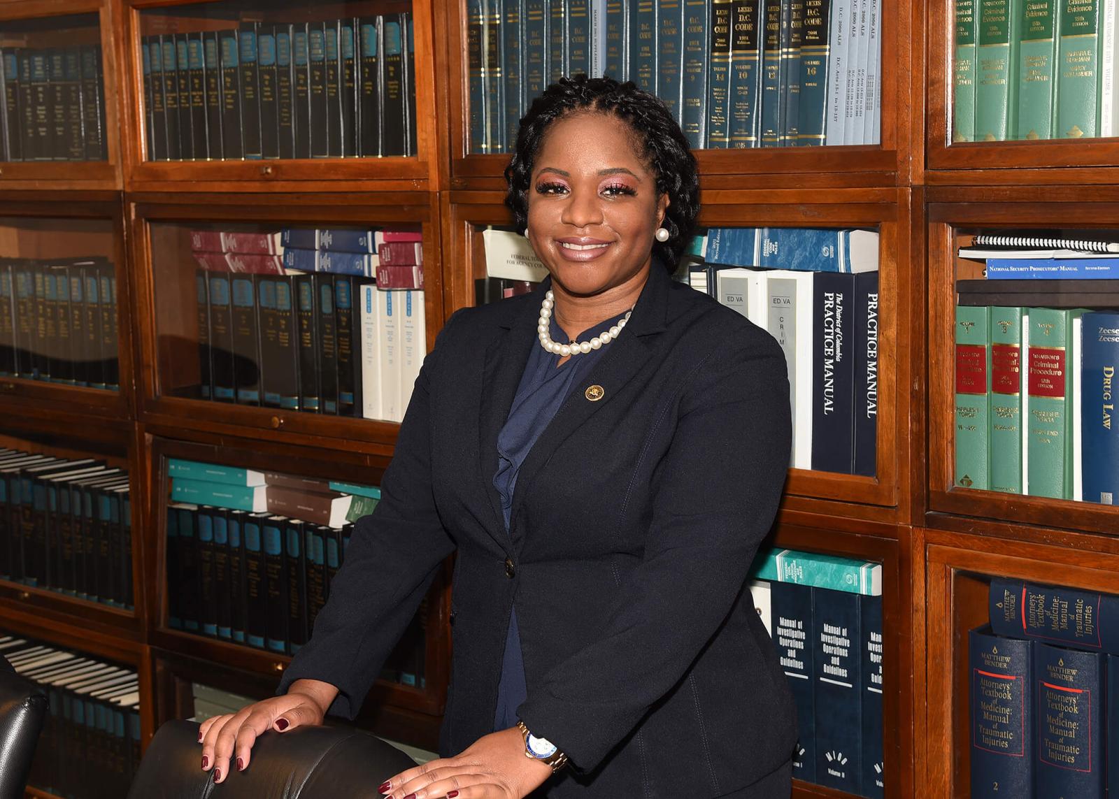 Takisha Black standing in front of a bookshelf of law books