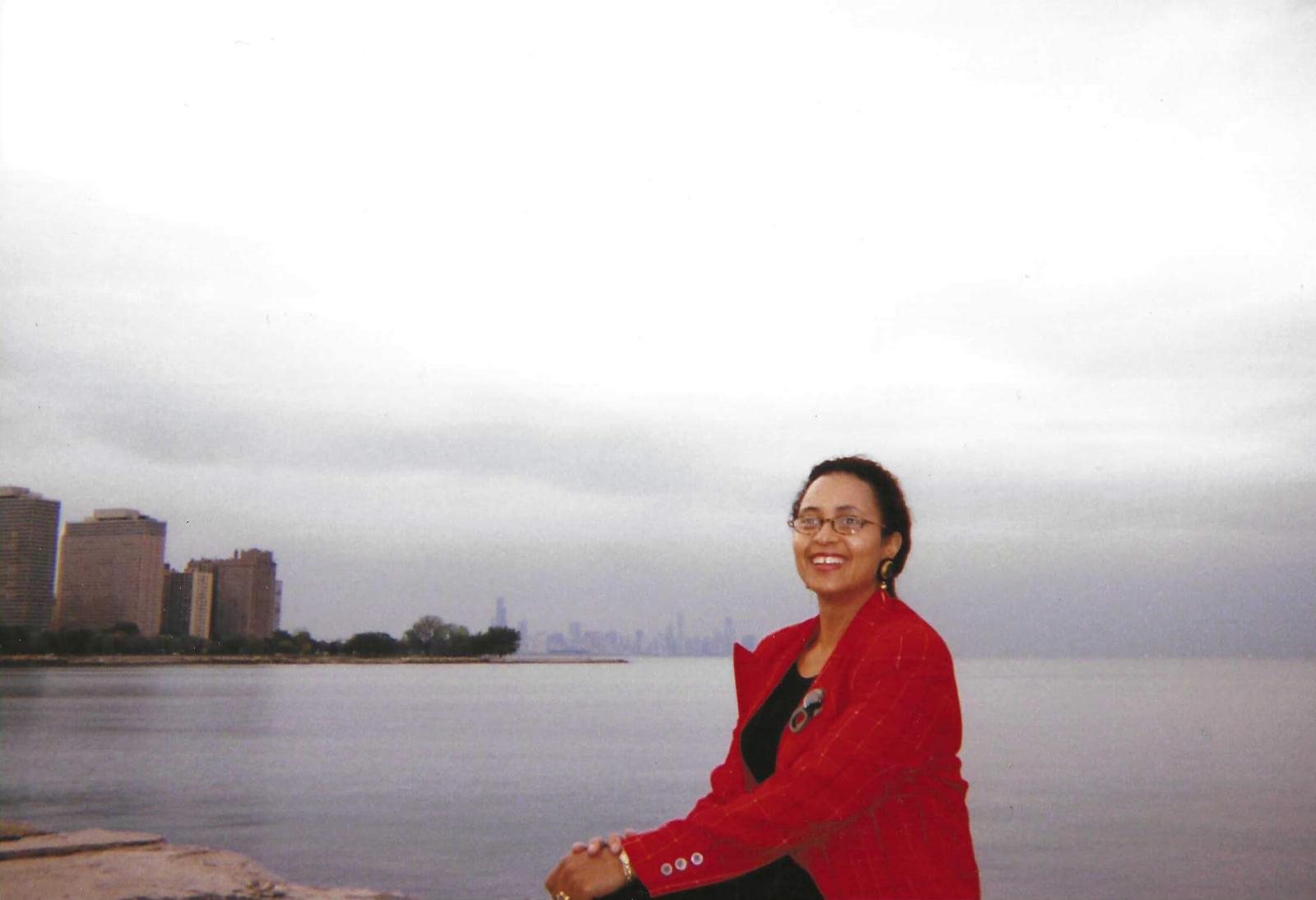 Christa Beverly in front of a lake with a city in the background