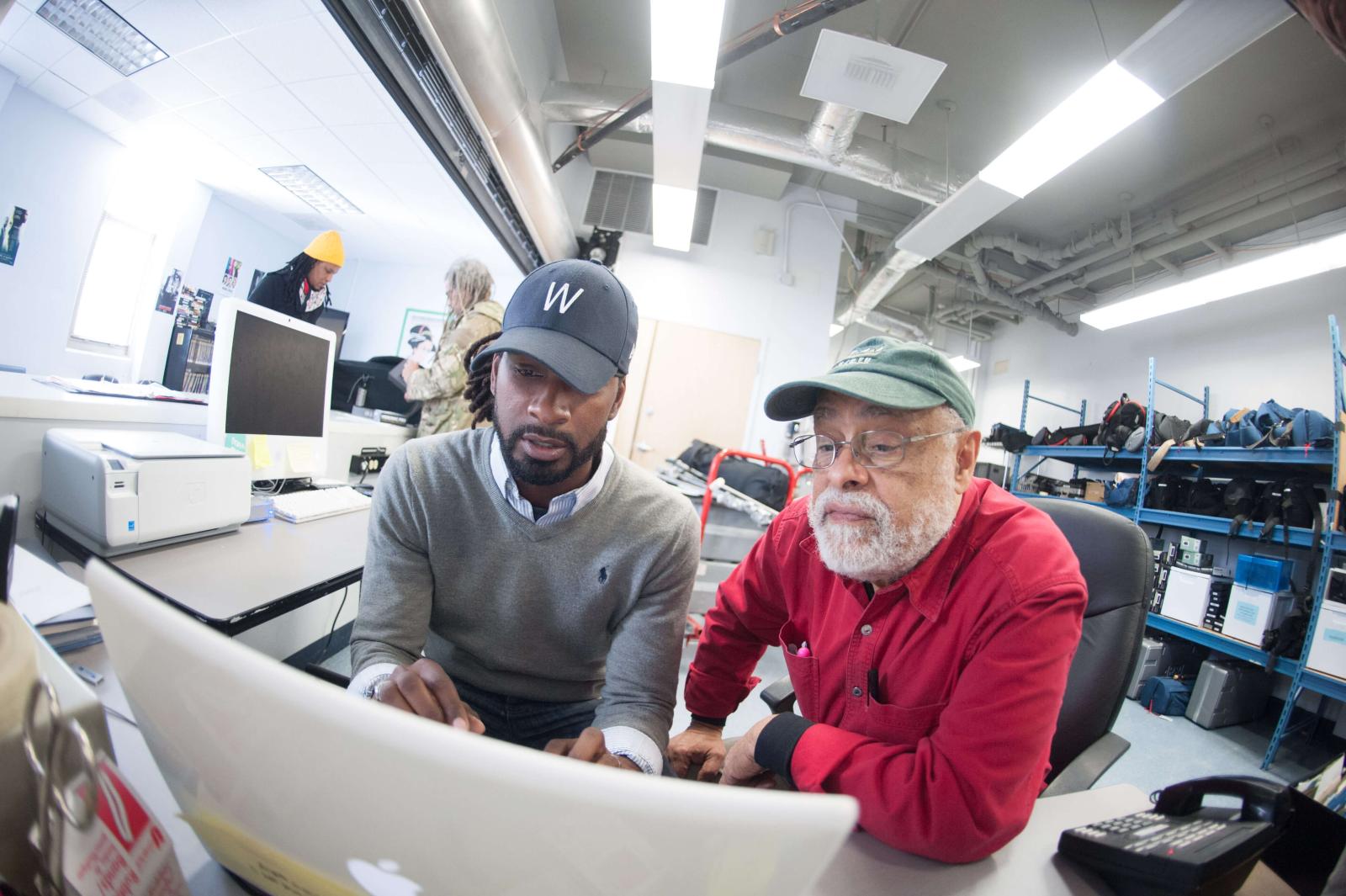 student and professor looking at a computer screen