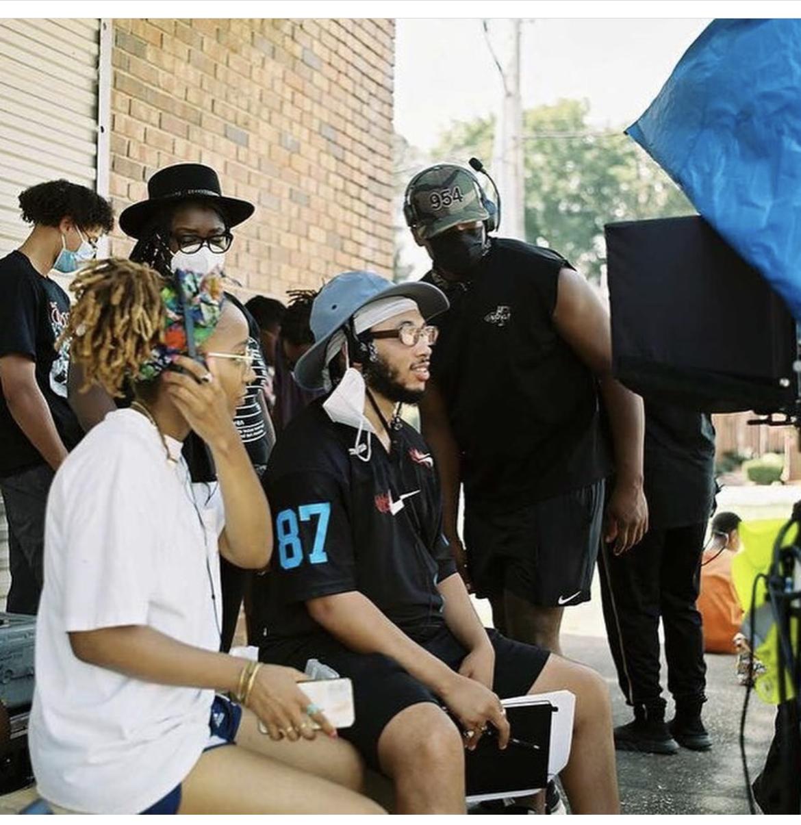 Two people sitting on a film set looking at a camera