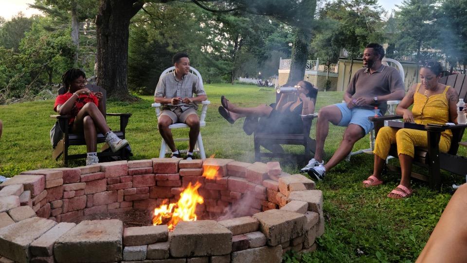 students gather around a firepit