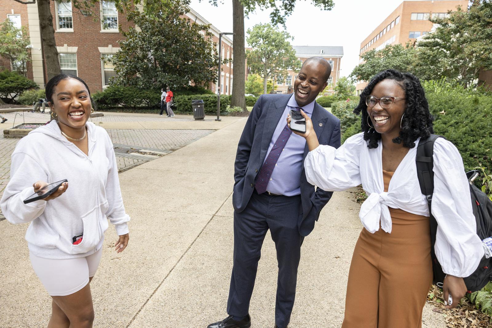 Dr. Frederick talks with students on campus. 