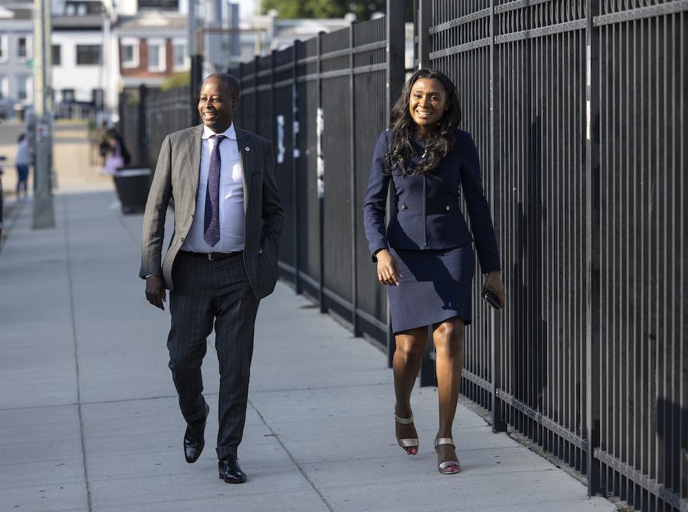 Dr. Frederick and Dr. Dubroy walking along a fence outside