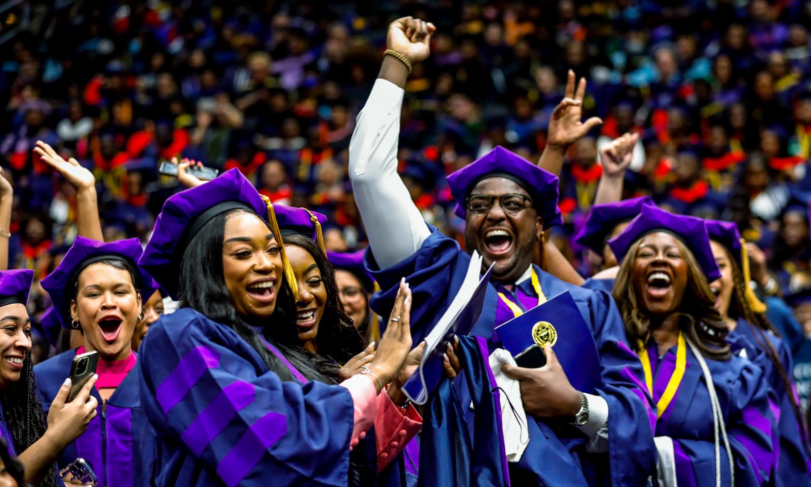 graduates in purple tams celebrate 