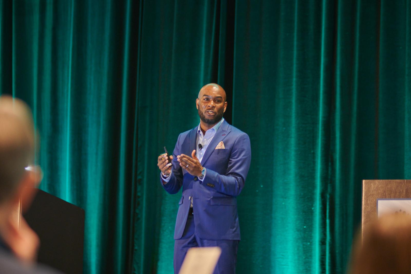 Lloyd Freeman in a suit walking past a green curtain