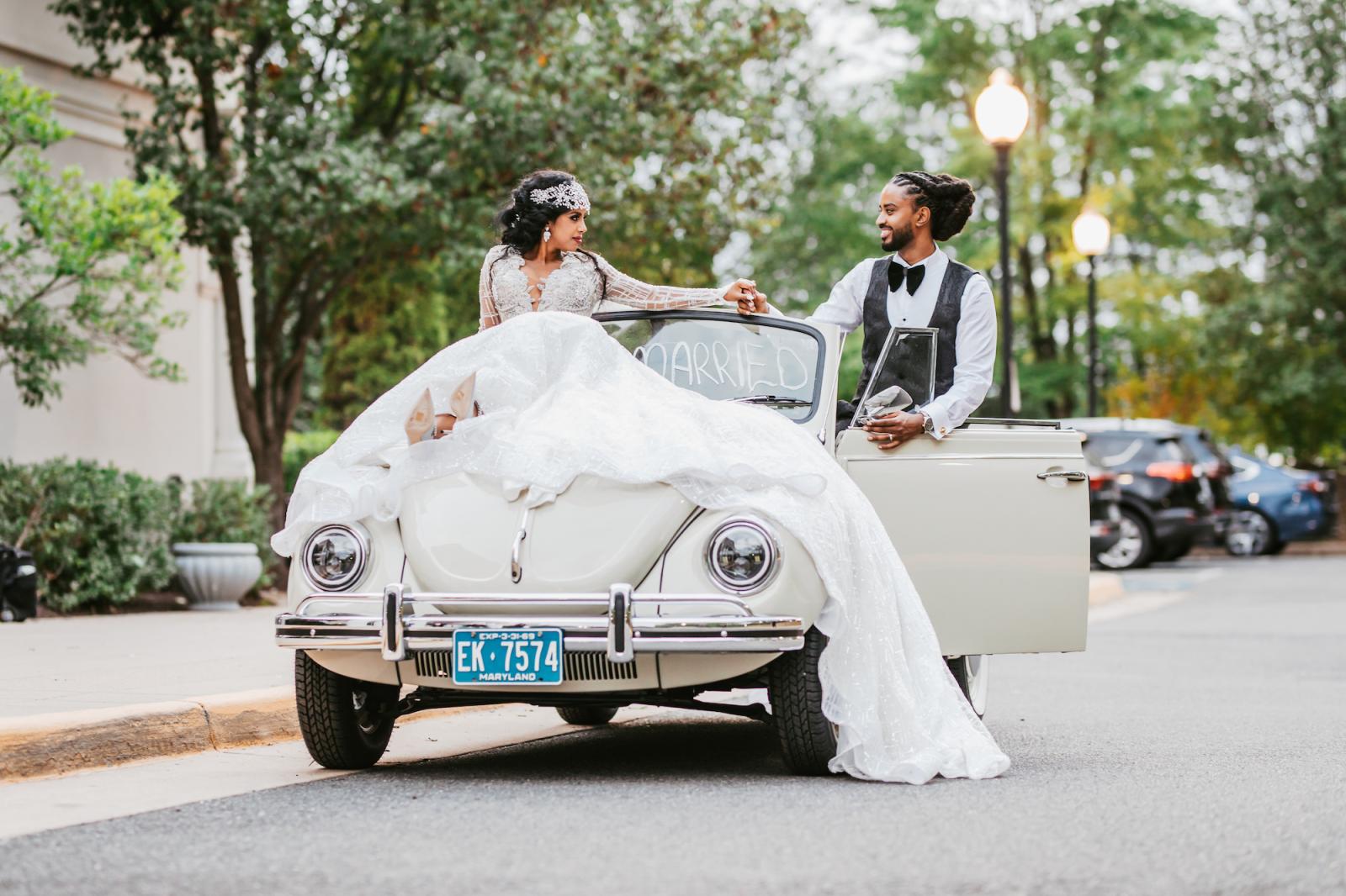 bride and groom in vintage VW Beetle