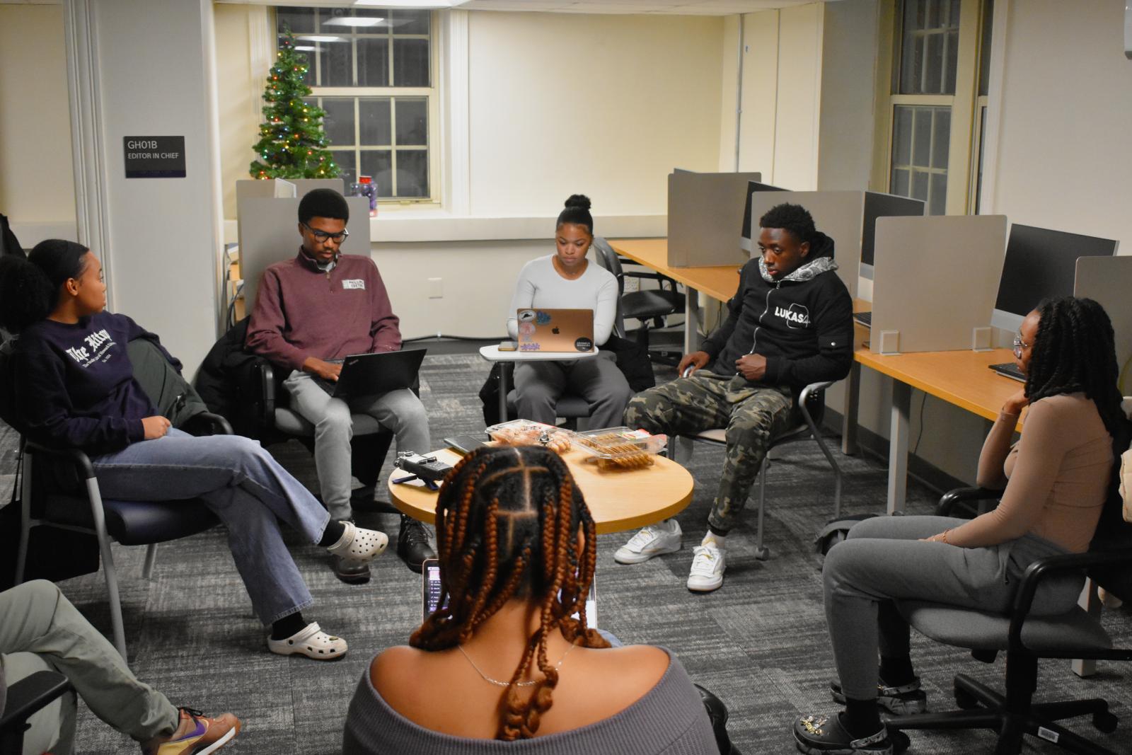 Current Hilltop staff writers and editors gather in a circle for an editorial meeting 