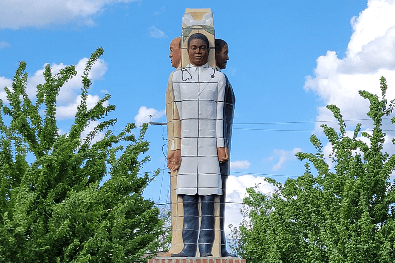 Statue of Howard University alumni in Augusta, Georgia. This image shows a person in grey coat.